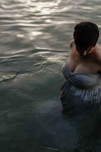 Rear view of shirtless woman in sea