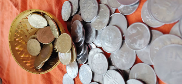 High angle view of coins in glass container on table