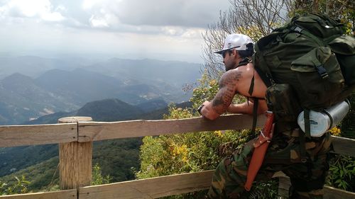 Rear view of man standing on railing