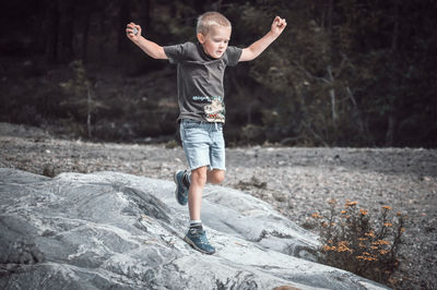 Full length of man jumping on rock