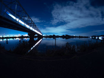 Bridge over river against sky at night