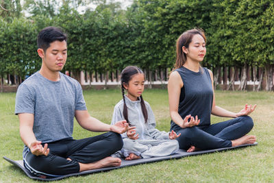 Serene people meditating while sitting at park