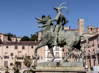 Low angle view of statue against building against sky