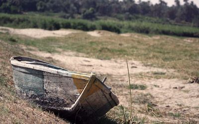 Abandoned boat on field