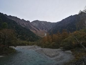 Scenic view of river amidst mountains against clear sky