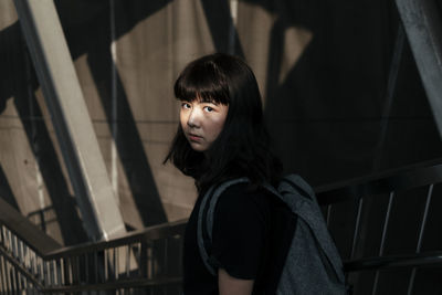 Portrait of woman standing by railing