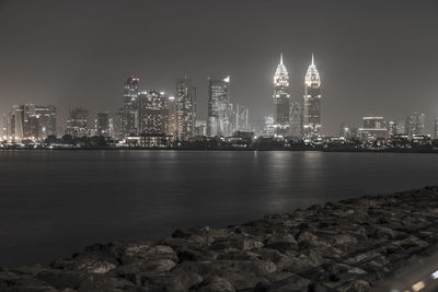 Illuminated buildings in city against sky at night