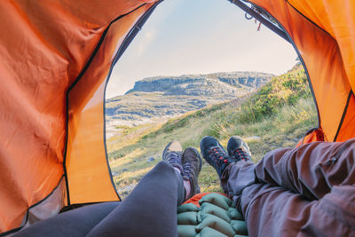 Low section of man relaxing in tent