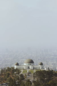 Buildings against sky in foggy weather