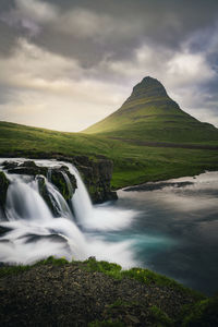 Scenic view of kirkjufell mountain and kirkjufellfoss waterfall, iceland, snæfellsnes peninsula. 