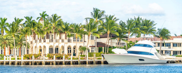 Panoramic view of palm trees and boats against sky