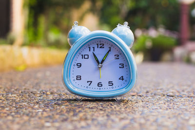 Close-up of alarm clock on road