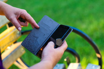 Cropped hand of woman using mobile phone