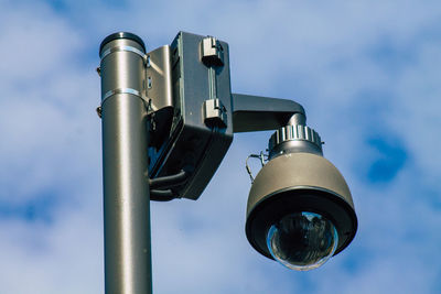 Low angle view of electric lamp against sky