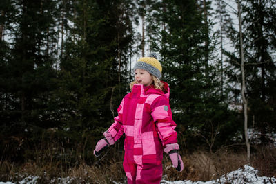 Young girl walking in the snow in a snowsuit in winter