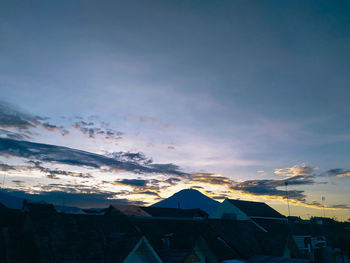 Low angle view of buildings against sky at sunset