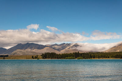 Scenic view of lake by mountains against sky