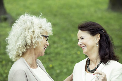 Happy senior female friends conversing in park