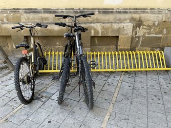 Bicycle parked on footpath against wall