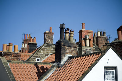 Rooftop view different chimney pots on quaint cottages in the fishing village of robin hoods bay