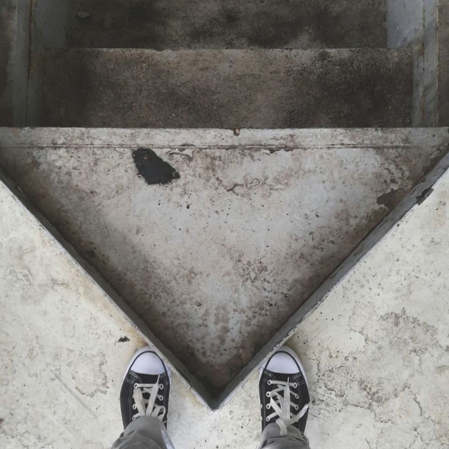 LOW SECTION OF PERSON STANDING ON TILED FLOOR