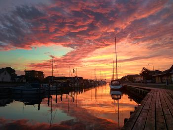 Boats moored at dock during sunset