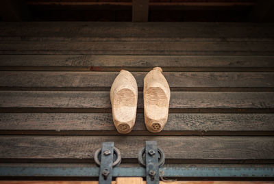 High angle view of wooden footwear on floorboard