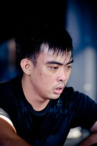 Close-up of man looking away while sitting in gym