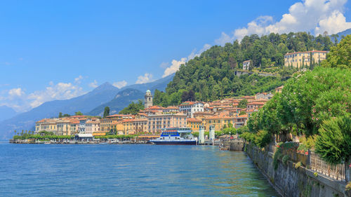 View of town by sea against cloudy sky