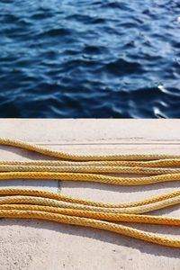 A vertical shot of a yellow boat rope lying on the ground of a marina