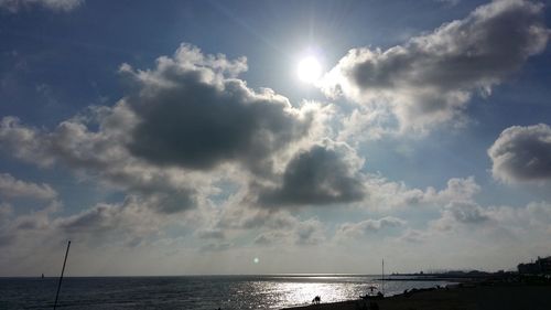 Sunlight streaming through clouds over sea