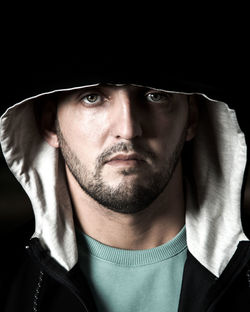 Close-up portrait of young man against black background