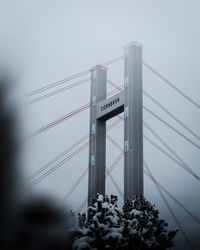Low angle view of suspension bridge against sky