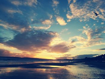 Scenic view of beach against dramatic sky