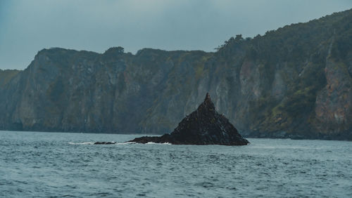 Rock formations in sea against sky