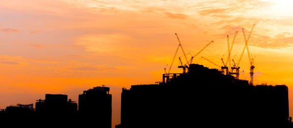 Silhouette buildings against sky during sunset