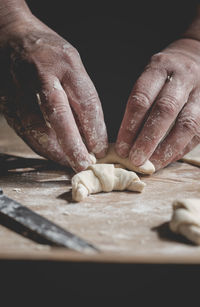 Close-up of hands preparing food on cutting board