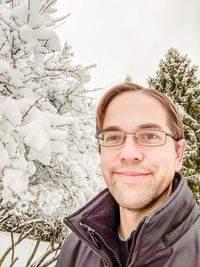 Portrait of smiling young man in snow