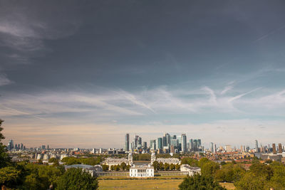 Buildings in city against cloudy sky