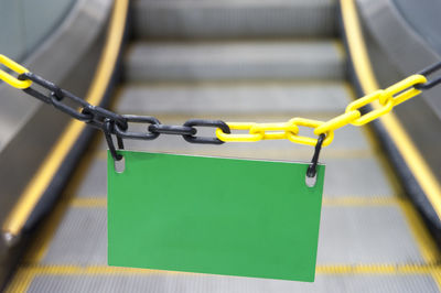 Close-up of yellow chain hanging on railing