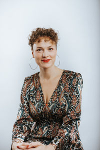 Portrait of smiling young woman against white background