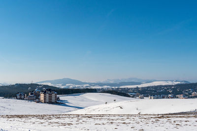 Scenic view of snowcapped mountains against clear blue sky