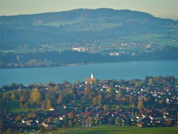 High angle view of city by sea against sky