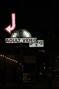 Low angle view of road sign at night