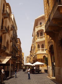 People walking on street amidst buildings in city