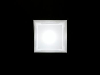 Close-up of illuminated lamp against black background