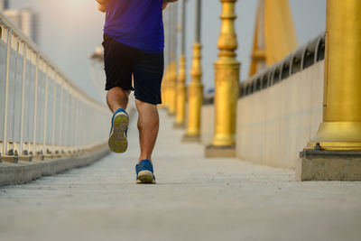 Low section of man running on footpath