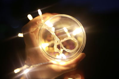 Close-up of hand holding burning candle