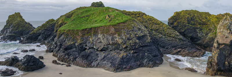 Rock formation in sea against sky