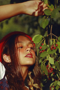 Teenage girl looking at berries on plant